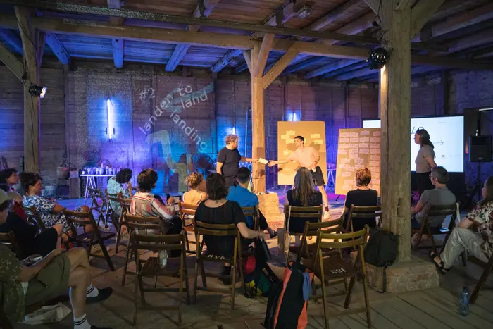 Auf Stühlen sitzende Menschen, die einer Präsentation folgen