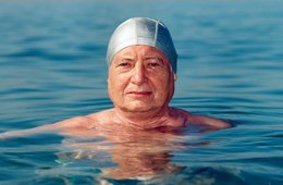 ein Mann schwimmend im Wasser mit Badekappe