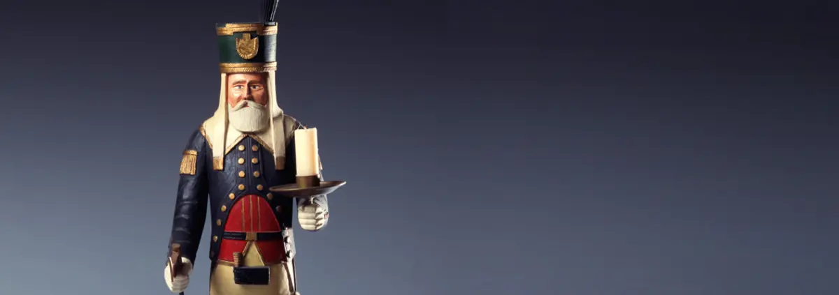 Eine Holzfigur mit weißem Bart in Uniform.