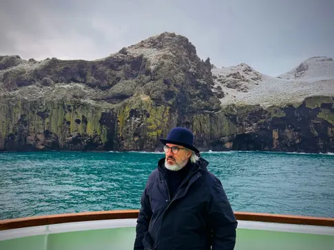 Mann mit Hut im Hintergrund Wasser und Berge