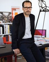 Konstantin Grcic leht an einem Schreibtisch in seinem Studio