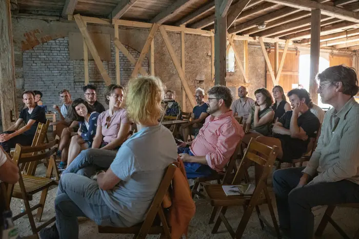 Eine Gruppe von Menschen, die in einem Raum auf Stühle sitzt