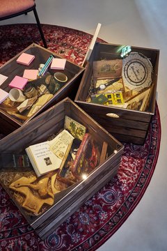 Blick in Kisten mit verschiedenen Gegenständen wie Tagebüchern, Uhr, Teller