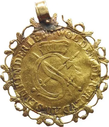 Münze mit Schnörkeln und einer Öse am Rand, auf der Münze Wappen