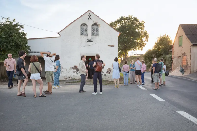 Eine Gruppe von Menschen, die vor einem Haus an einer Straße stehen
