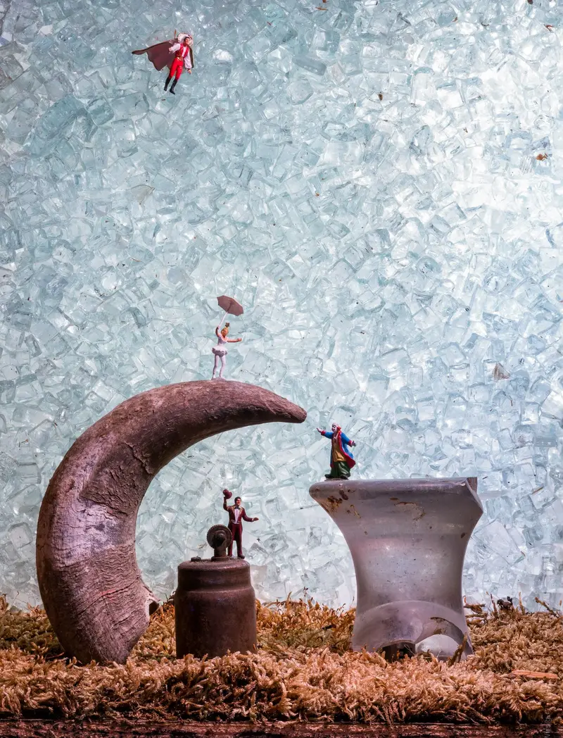 Tanzende Menschen, die auf Objekten wie einem Horn stehen.