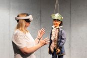 Bühne ohne Grenzen Person mit VR Brille vor einer Marionette