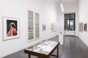 Ausstellungsansicht "20 Jahre Gerhard Richter Archiv" Raumansicht mit Vitrinen und unterschiedlich großen gerahmten Bildern