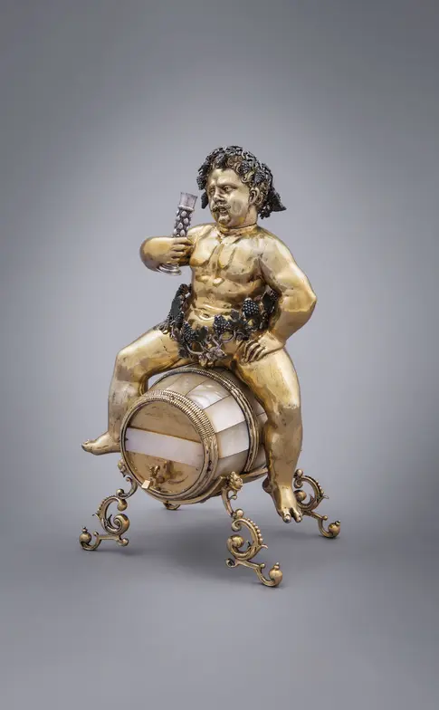 Figur mit einem Glas Wein in der Hand sitzt auf einem Weinfass