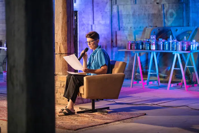 Eine in einem Sessel sitzende Frau mit Mikrofon