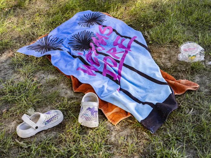 Handtuch und Badeschuhe auf Rasen