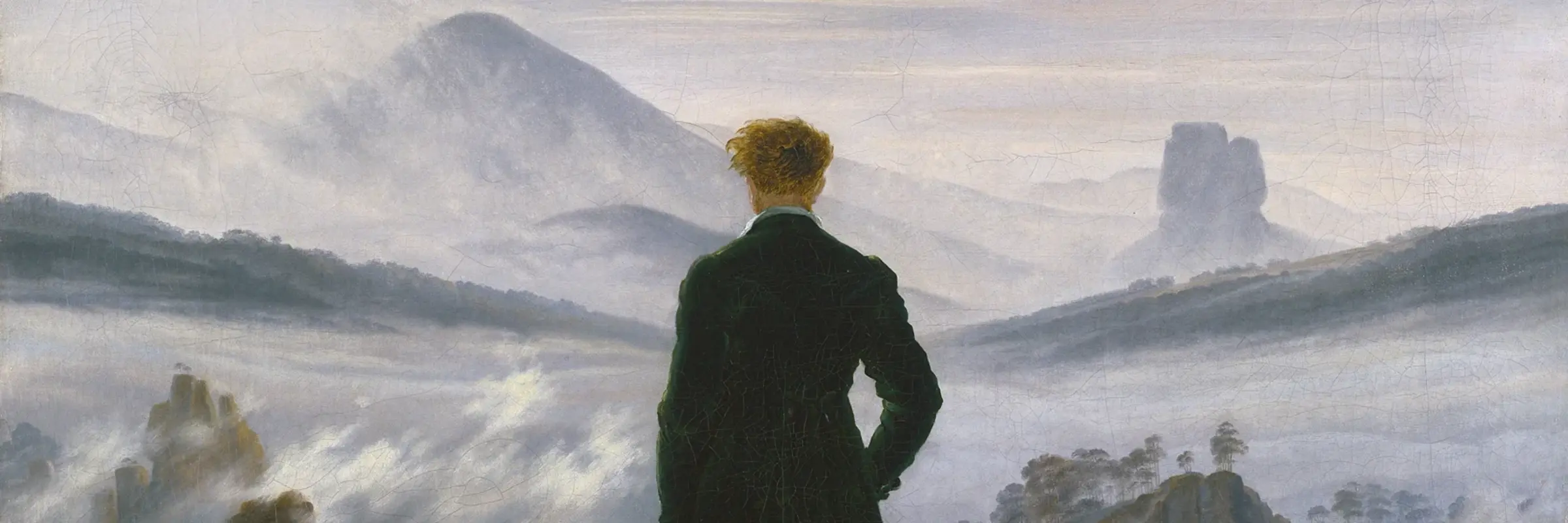 Ein Mann steht auf einem Felsen schaut sich Nebel an 