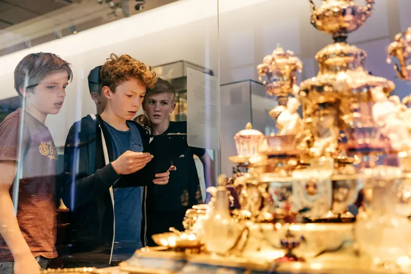 Drei Jungen stehen vor einem Museumsexponat  