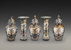 fünf Porzellanvasen reich dekoriert und symmetrisch aufgestellt
