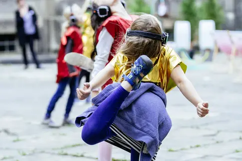 Kind steht auf einem Bein, Kopfhörer auf