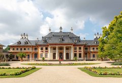 Vor dem Bergpalais eine Gartenanlage mit Teich und Wasserfontäne