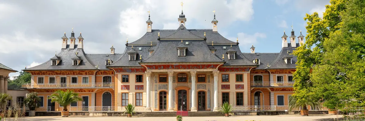 Vor dem Bergpalais eine Gartenanlage mit Teich und Wasserfontäne