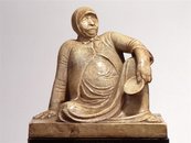 Skulptur einer sitzenden, sich abstützenden Person mit Haube, trägt ein Schälchen