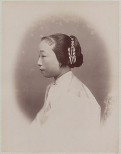 Seitenportrait einer Frau, mit Haarschmuck befestigter, großer Dutt