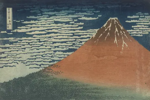 Roter Berg vor blauem Himmel mit weißem Wind.