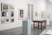 Ausstellungsansicht "20 Jahre Gerhard Richter Archiv" Raumansicht mit Vitrinen und unterschiedlich großen gerahmten Bildern