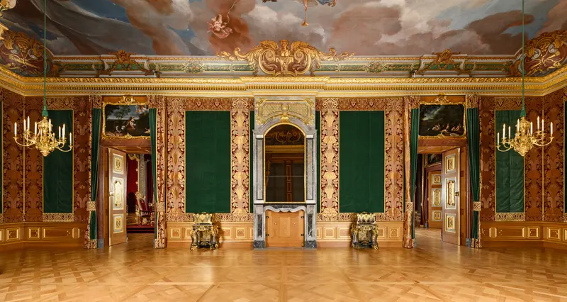 Großer, reich verzierter Raum mit Kronleuchtern, Deckenmalerei und Goldelementen