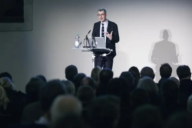 ein Mann im Anzug hält einen Vortrag