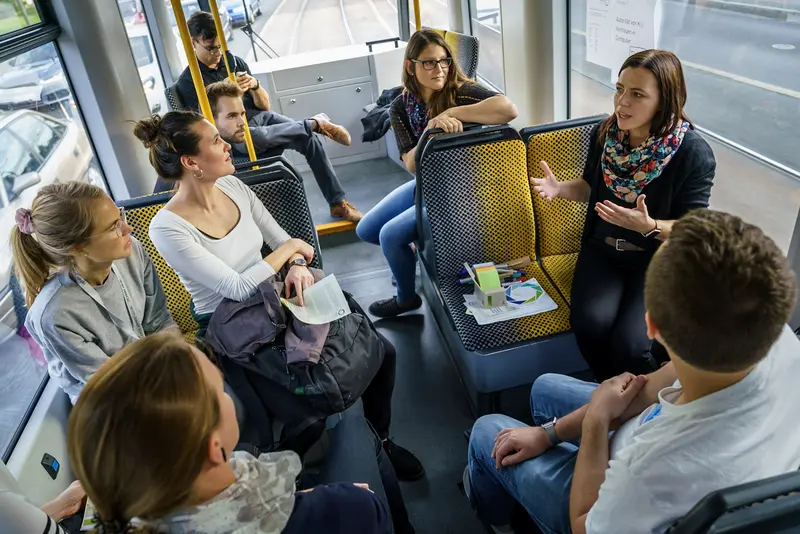 Junge Personen diskutieren in einer Straßenbahn