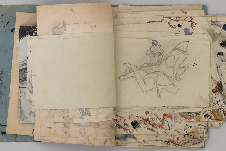 Aufgeschlagenes Skizzenbuch mit unterschiedlichen Blattgrößen, oben auf eine Zeichnung von Körpern
