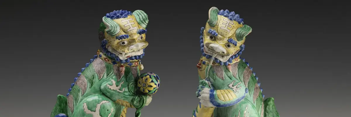 zwei Löwen der Qing Dynastie in grün leuchtendem Porzellan blicken einander an