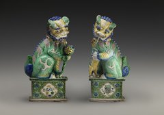 zwei Löwen der Qing Dynastie in grün leuchtendem Porzellan blicken einander an