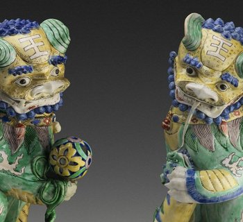 zwei Löwen der Qing Dynastie in grün leuchtendem Porzellan blicken einander an