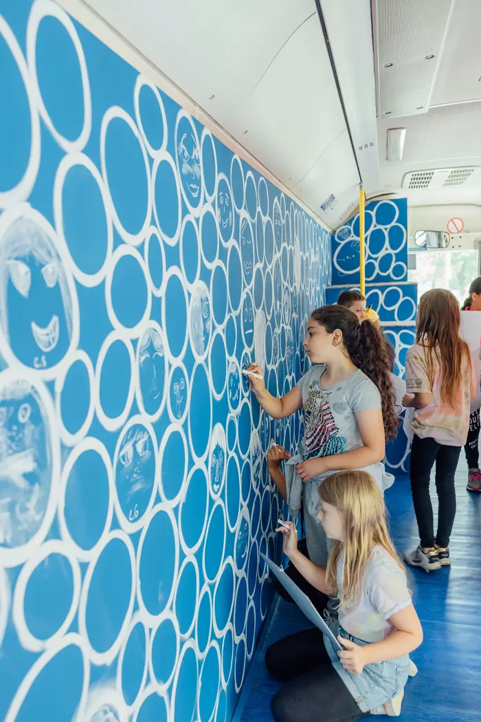 Kinder, die eine Wand gestaltet