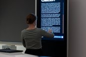 Ausstellungsansicht "Krypto, was?" Person an einer digitalen Stele