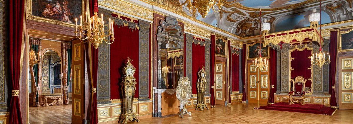 Großer, prunkvoller Raum mit Thron, Kerzenleuchter und Deckenmalerei