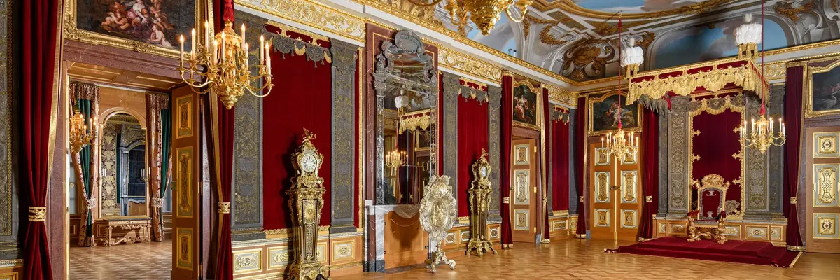 Großer, prunkvoller Raum mit Thron, Kerzenleuchter und Deckenmalerei