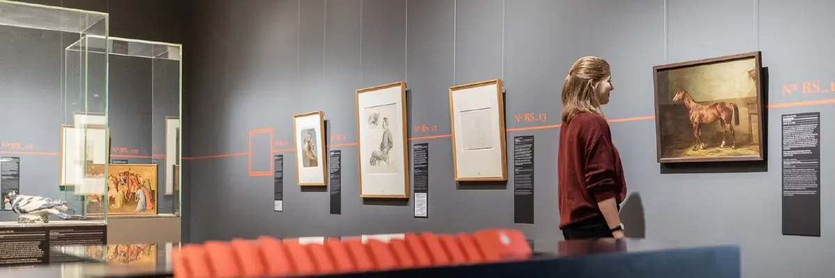 Ausstellungsraum mit Vitrinen und Gemälden