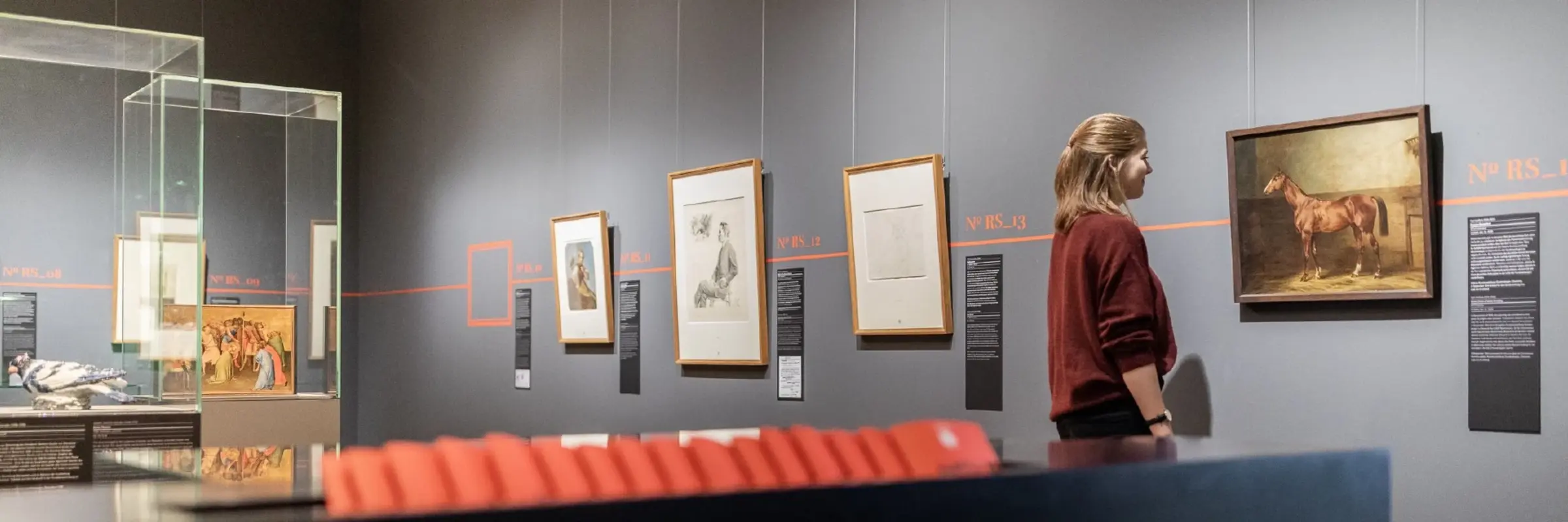 Ausstellungsraum mit Vitrinen und Gemälden