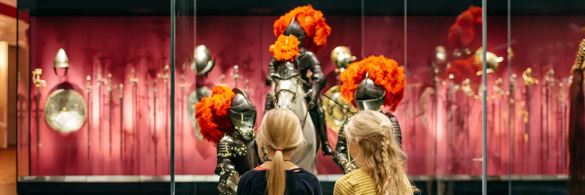 Zwei Kinder, die Ritterrüstungen von Kindern betrachten