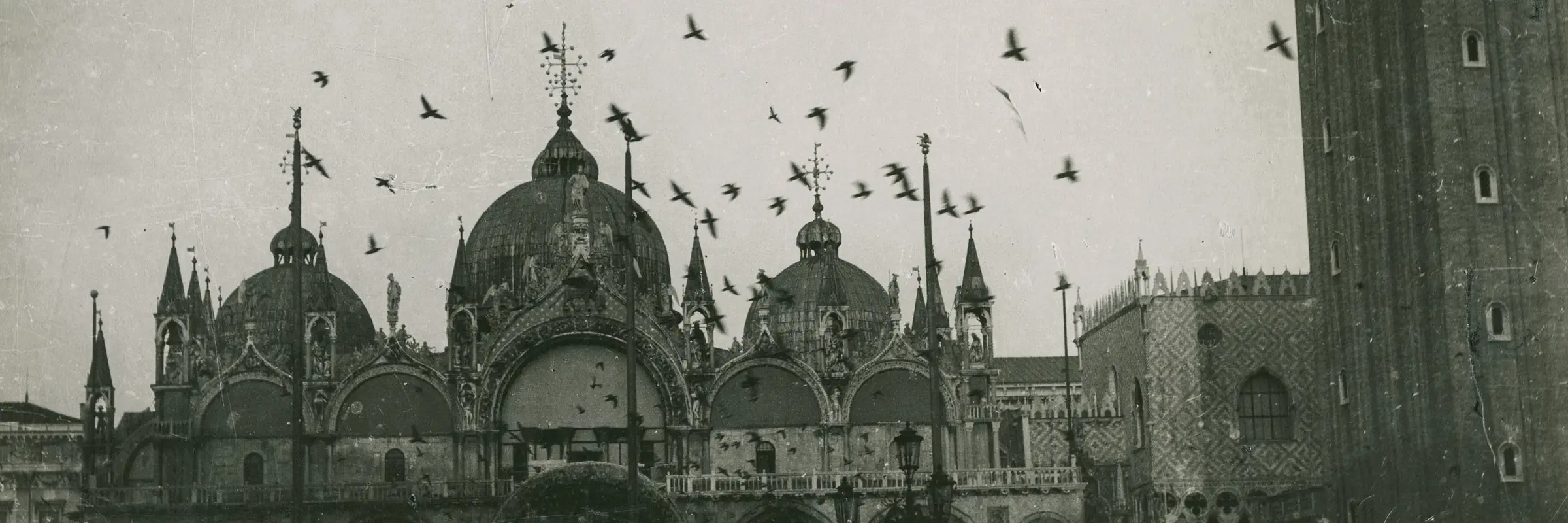 schwarz-weiß Foto eines Flugzeugs über dem Markusplatz in Venedig