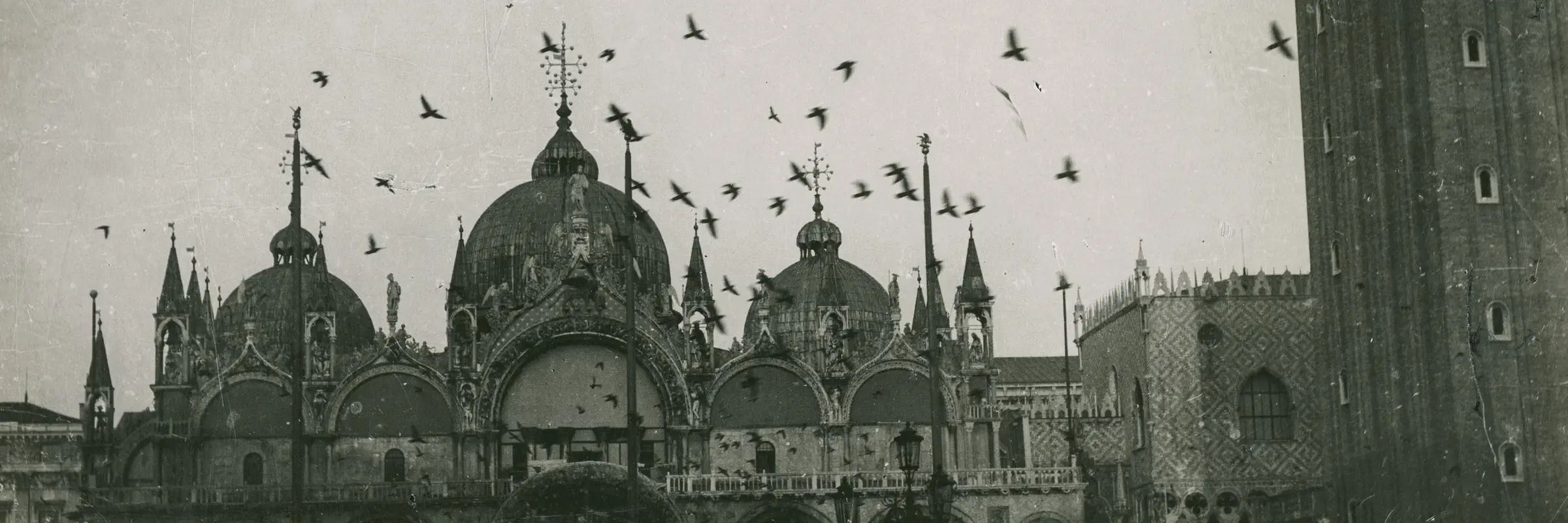 schwarz-weiß Foto eines Flugzeugs über dem Markusplatz in Venedig
