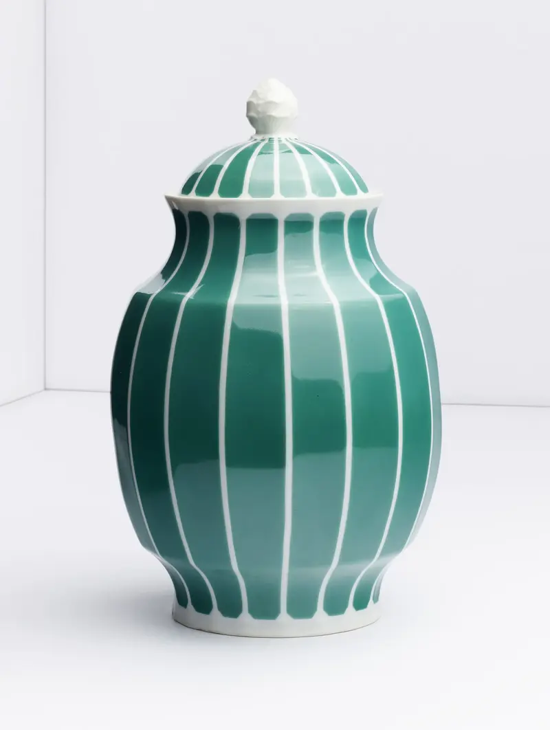 Eine grüne Vase mit weißen Streifen und Deckel