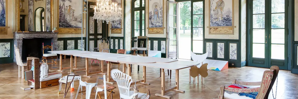 Raum mit langem, zusammengesetztem Tisch und verschiedenen Sitzen