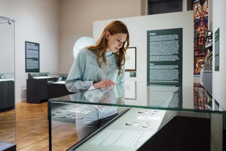 Frau vor einer Vitrine im Ausstellungsraum