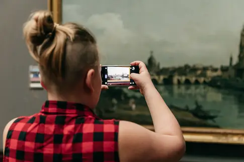 Eine Besucherin fotografiert ein Gemälde von Bernardo Bellotto