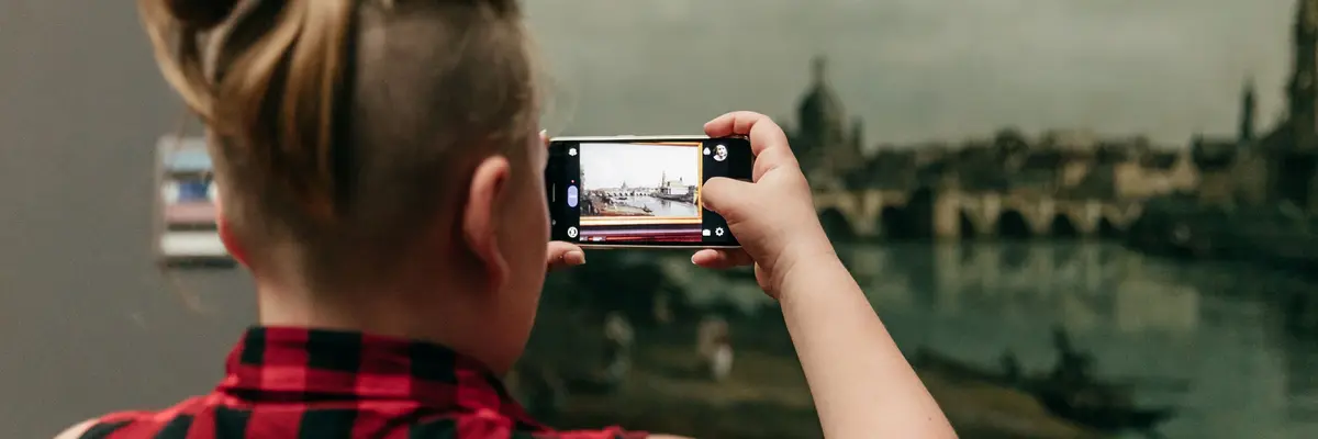 Eine Besucherin fotografiert ein Gemälde von Bernardo Bellotto