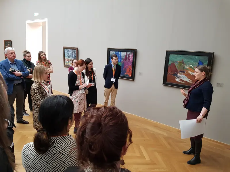 Kunstvermittlerin und Teilnehmende einer Führung in einem Ausstellungsraum