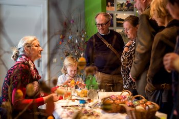 Tisch mit Ostereiern, drumherum Besucher