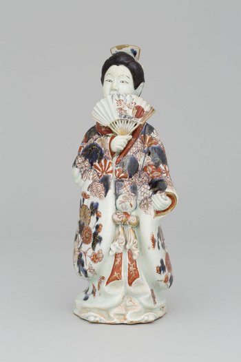 Porzellanfigur einer Frau, hält Fächer vors Gesicht, trägt Gewand mit Blumenmuster