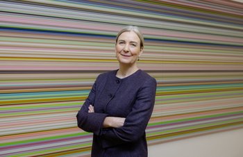 Frau, die vor einem Kunstwerk in einer Ausstellung steht